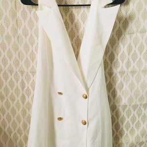 All white, sleeveless blazer .